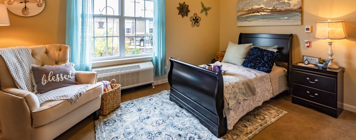 A cozy bedroom with a single bed, decorative wall art, and ample natural light streaming through the window.