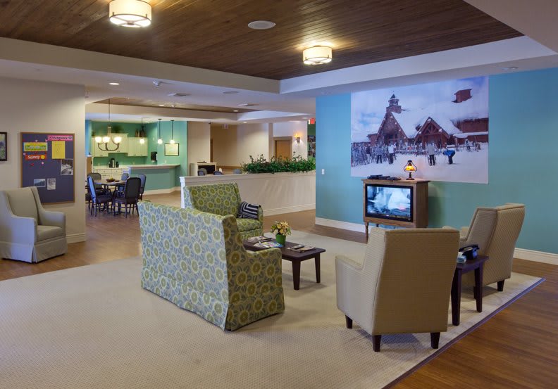 A modern lobby area with comfortable seating and a television near the reception desk.