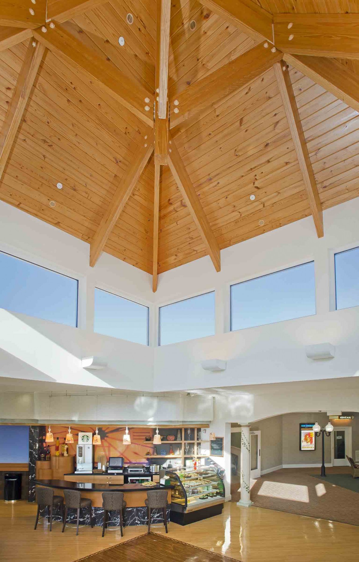 A bright and spacious modern interior with a high wooden ceiling and ample natural light.