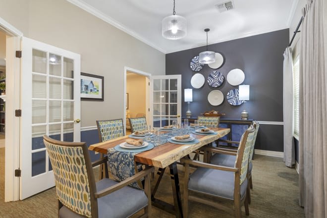 A modern dining room featuring a wooden table, stylish chairs, and decorative wall art.