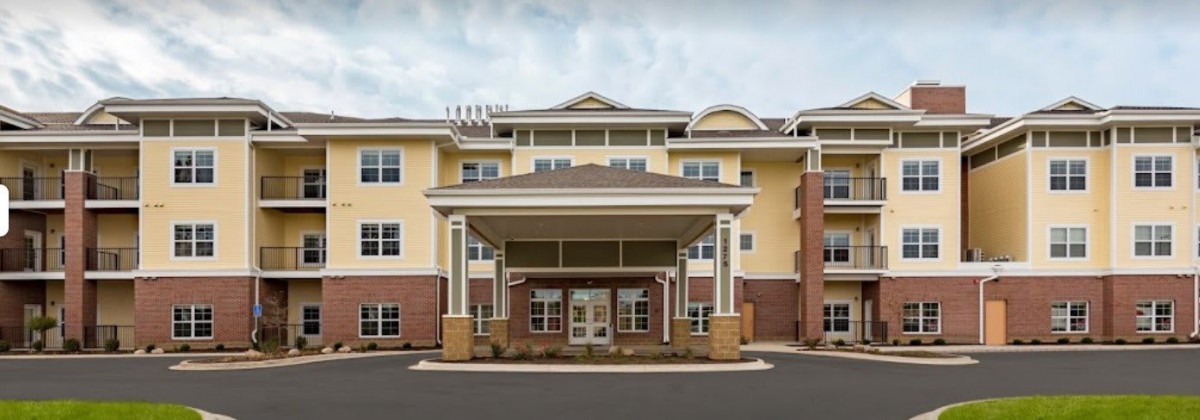A modern multi-story building with a central entrance and covered porch.