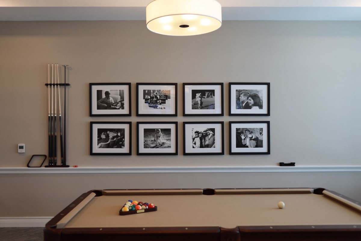 A stylish game room featuring a pool table and framed photographs on the wall.
