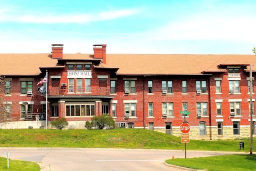 An elegant historic red brick building showcasing classic architectural elements against a clear blue sky.