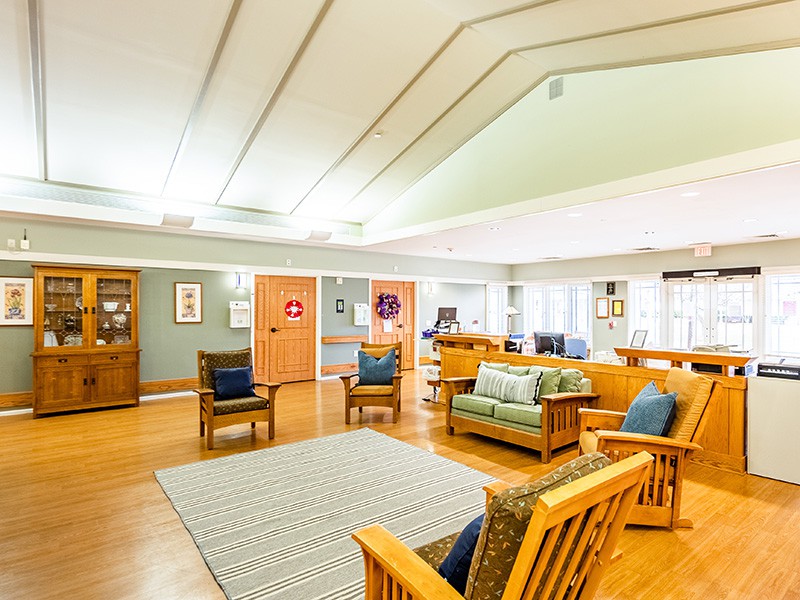 A bright and cozy living room featuring wooden furniture and a seating area.