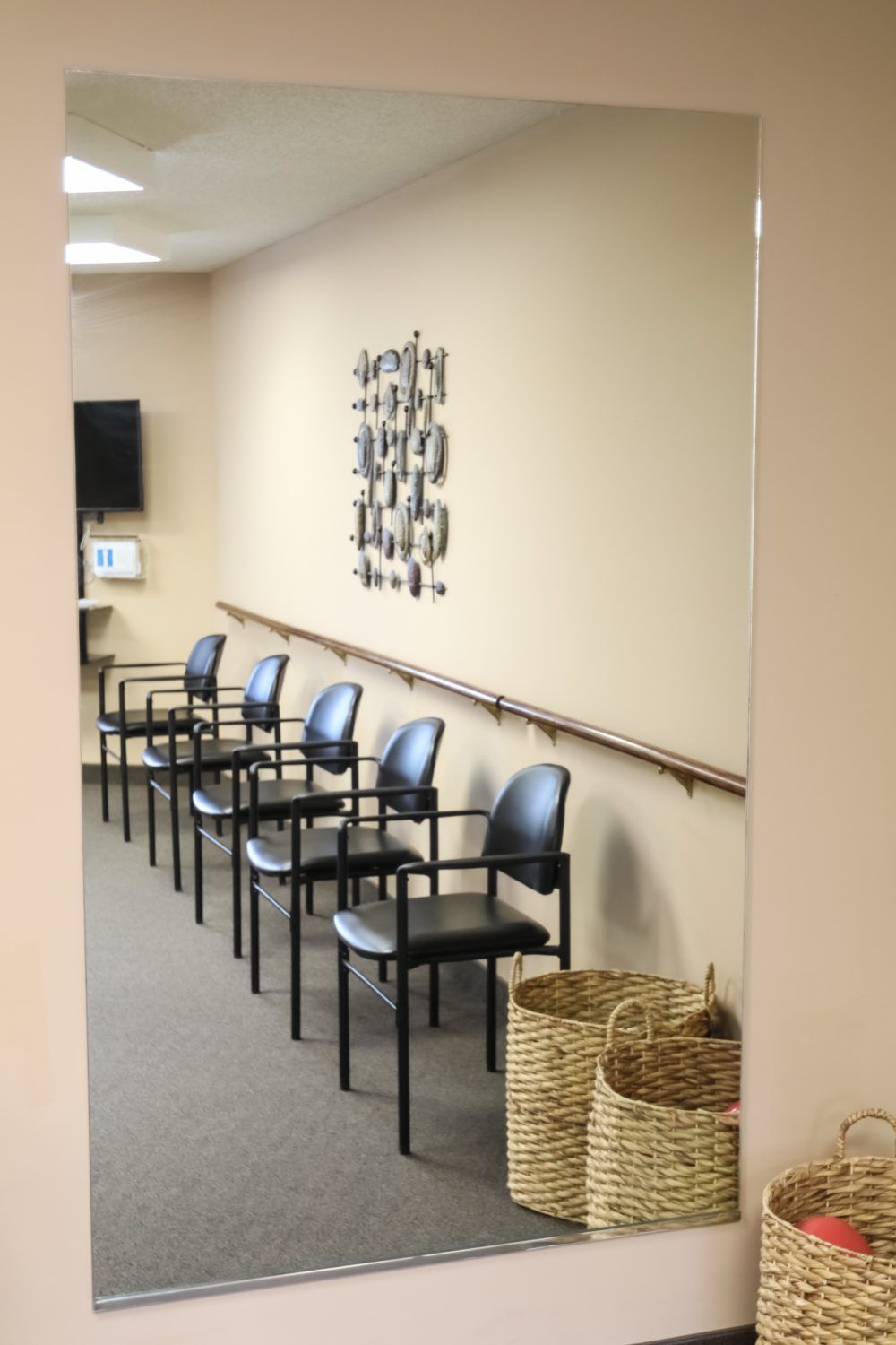 A waiting room with a row of chairs and baskets for storage.