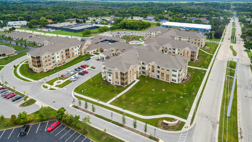 Aerial view of a modern apartment complex with landscaped grounds and parking areas.