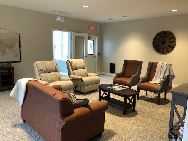 A cozy living room with comfortable seating arrangements, including sofas and chairs around a coffee table.