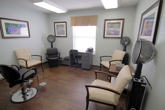 A cozy waiting room with comfortable chairs and decorative paintings on the walls.