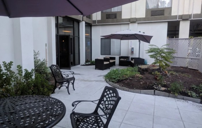 A cozy patio area with comfortable outdoor seating and garden umbrellas.