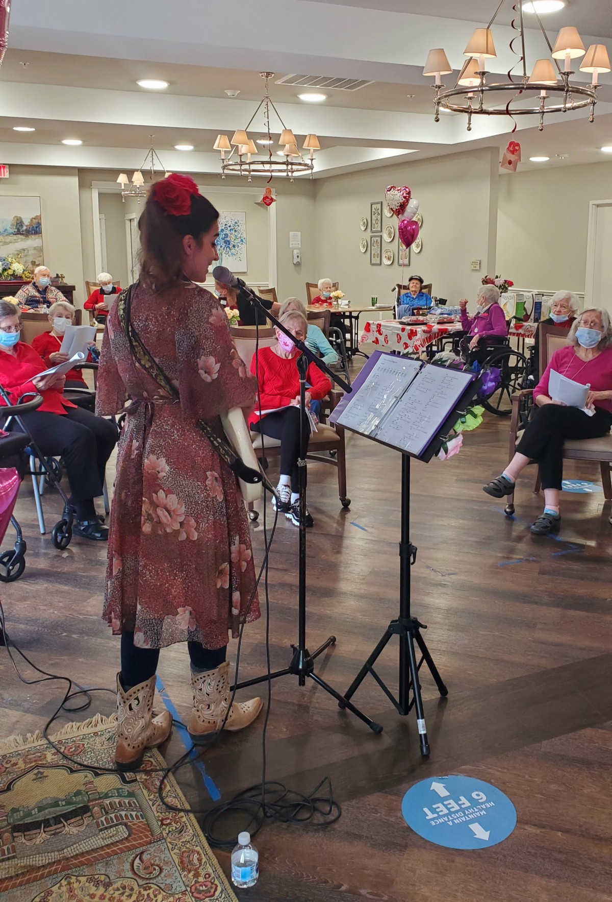 A singer performs in front of an audience at a senior community center.