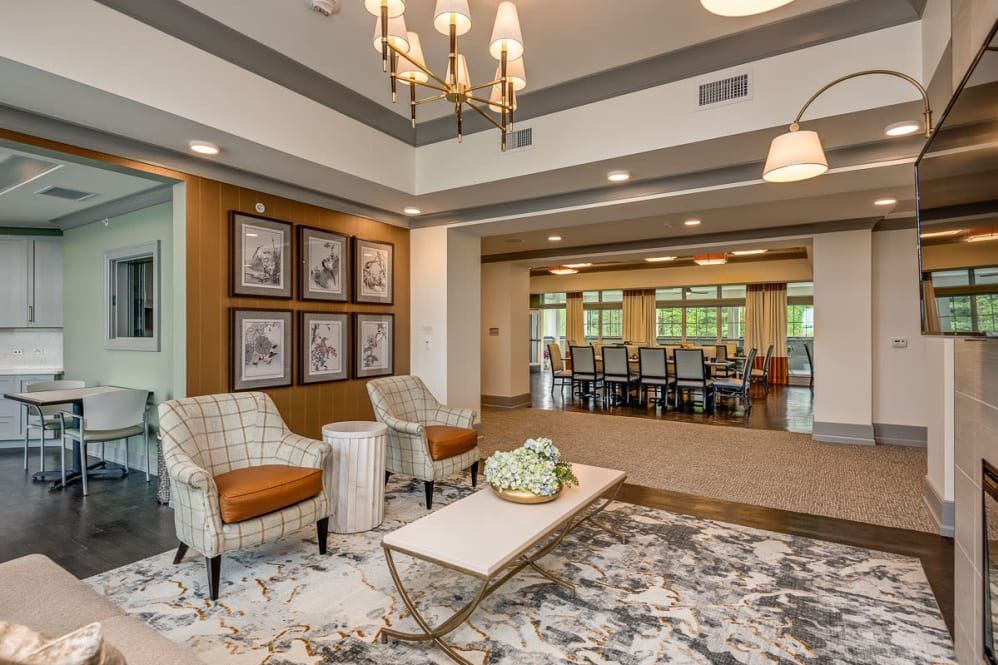 A modern and elegantly decorated living room featuring comfortable seating, a chandelier, and stylish furnishings.