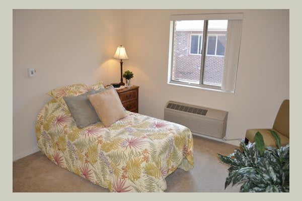 A cozy bedroom with a floral bedspread and soft lighting.