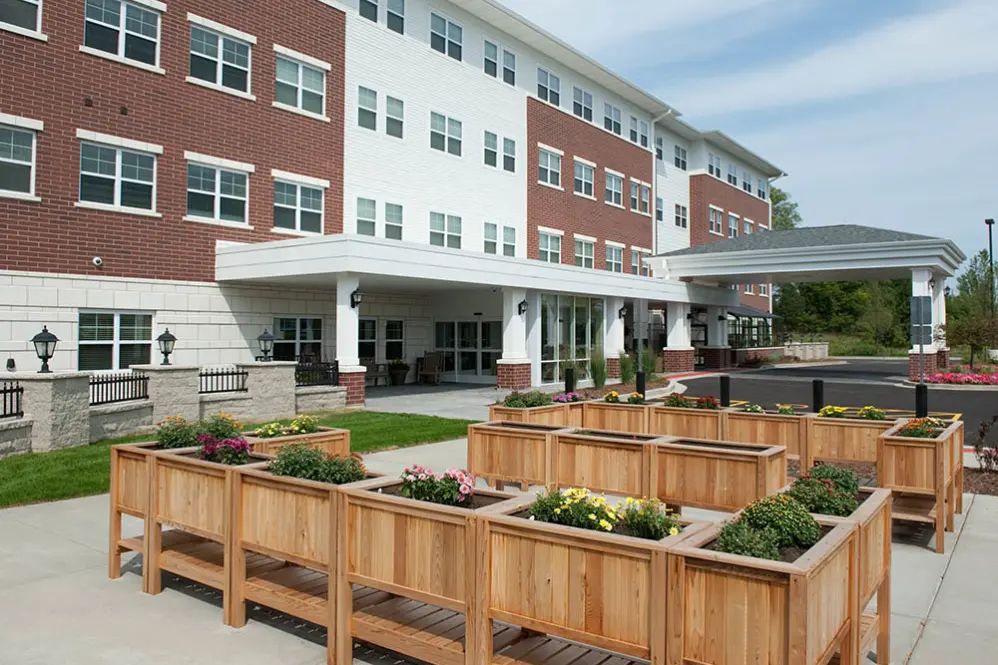 A modern apartment building with wooden planters in the foreground.