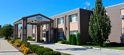 A well-maintained hotel building with a welcoming entrance and clear blue skies.