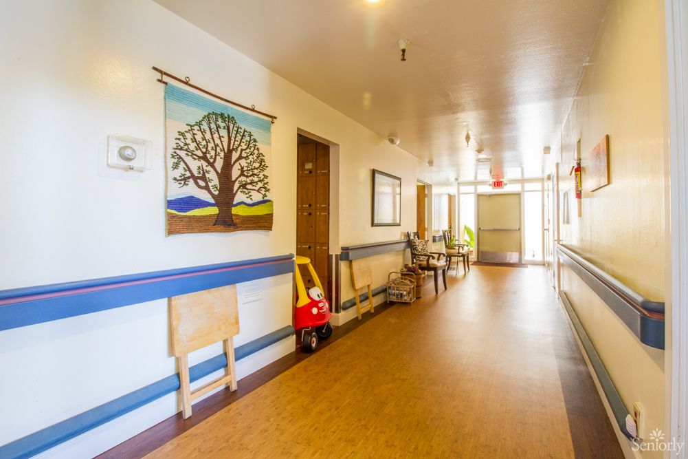 A brightly lit hallway with artwork on the wall and children's furniture.