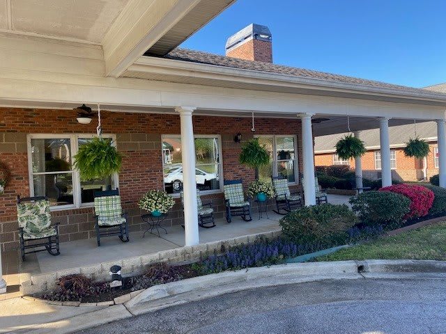 An inviting porch with chairs and hanging plants.