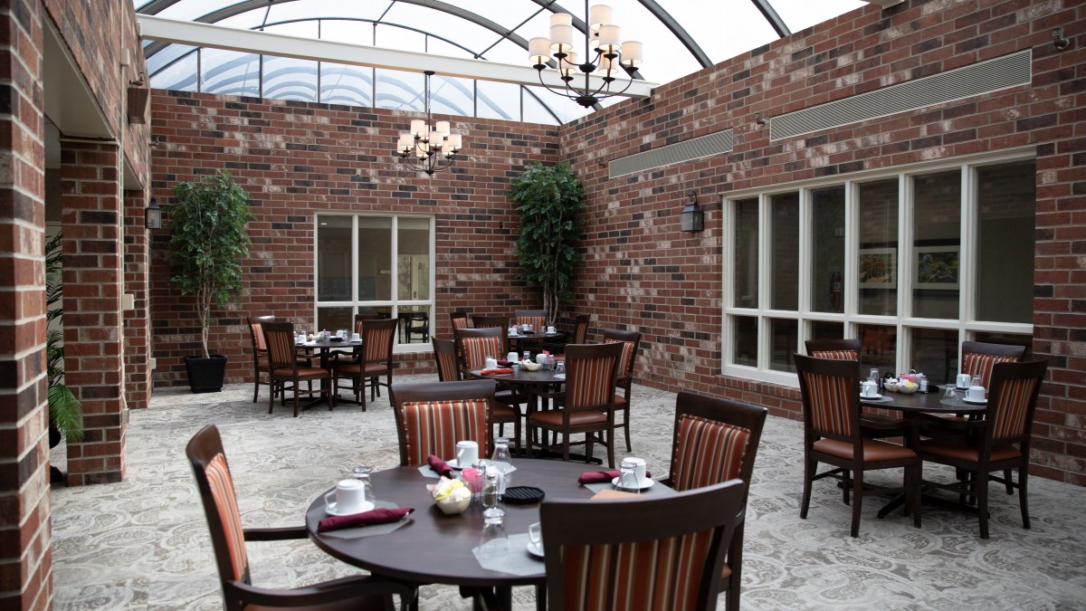A cozy indoor dining area with brick walls and ceiling chandeliers.