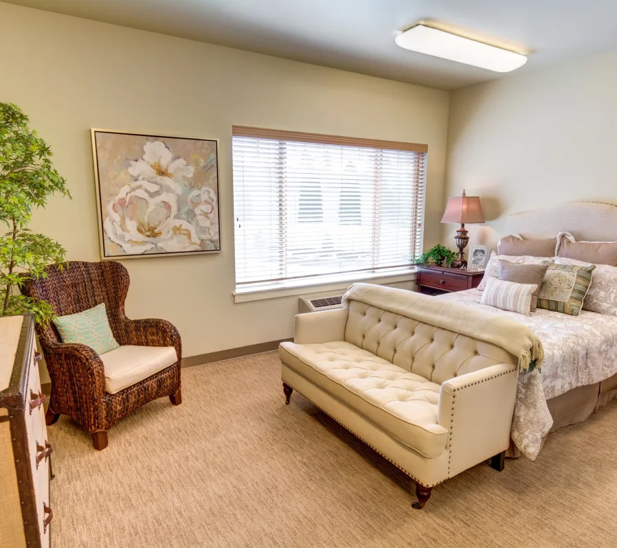 A cozy bedroom with a couch, bed, and ample natural light.