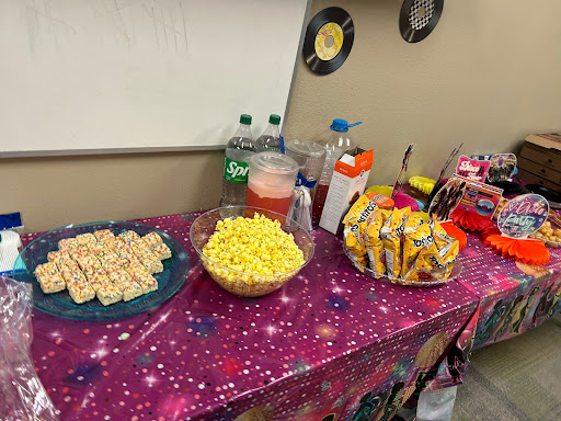 A festive snack table featuring popcorn, drinks, and assorted treats.