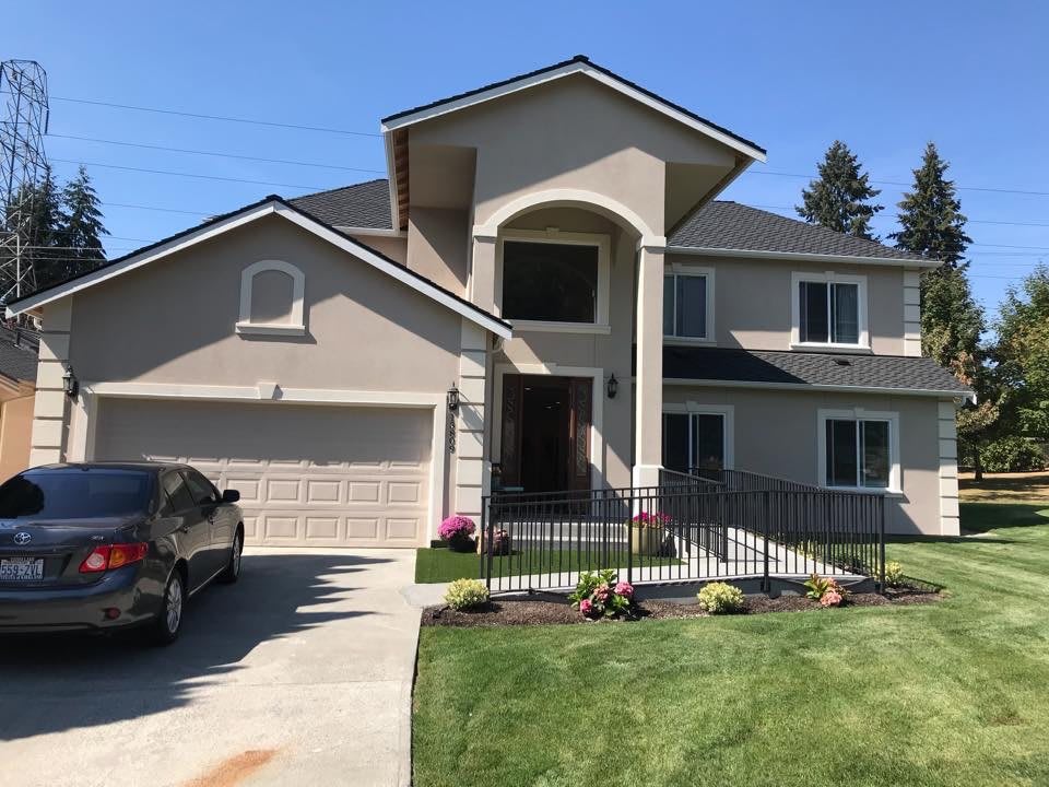 A modern two-story house with a driveway and neatly landscaped lawn.