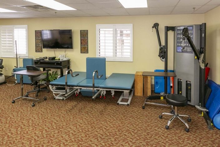A physical therapy room equipped with various rehabilitation tools and a therapy table.