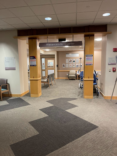 Entrance to a hospital with a waiting area and medical rooms visible.