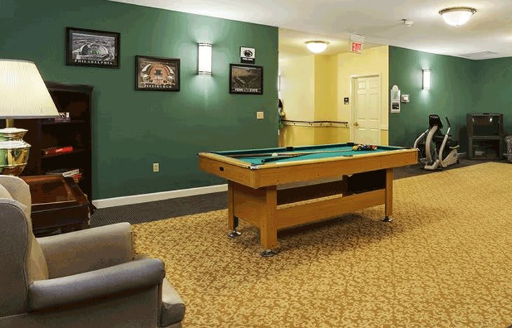 A cozy game room featuring a pool table and comfortable seating.