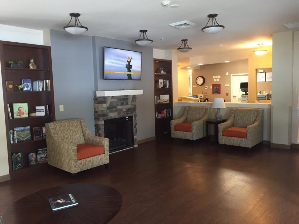 A cozy living room area with comfortable chairs, a fireplace, and a television.