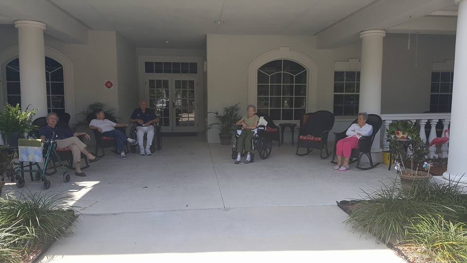 People sitting outdoors on a patio near a building.
