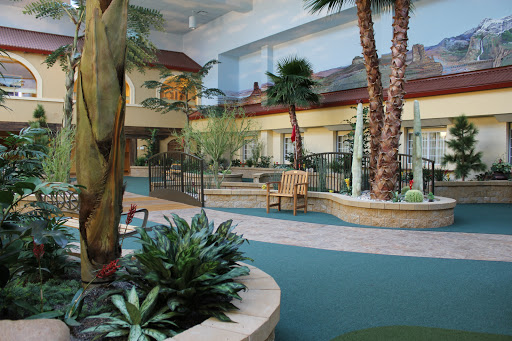 An inviting indoor landscape featuring lush greenery and palm trees in a hotel atrium.