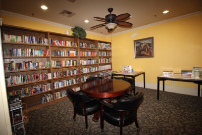 A cozy library reading room with bookshelves and a round table.