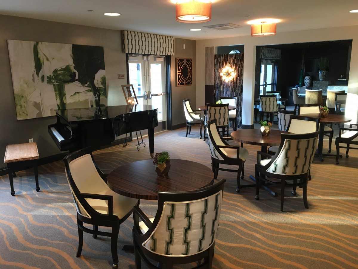 A stylish lounge area featuring elegant seating arrangements and a piano.
