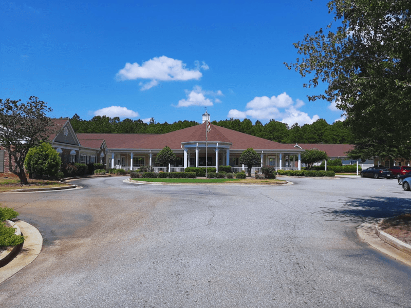 A large building surrounded by trees with a clear blue sky above.