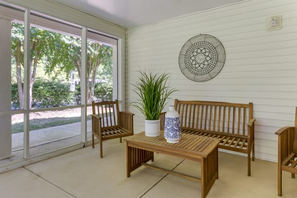 A cozy sunroom with wooden furniture and decorative accents.