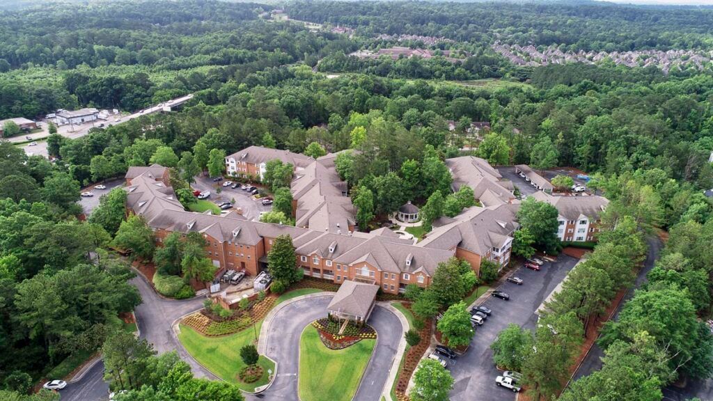 Aerial view of a large building complex surrounded by lush greenery.