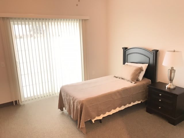 A minimalist bedroom with a single bed and neutral tones.