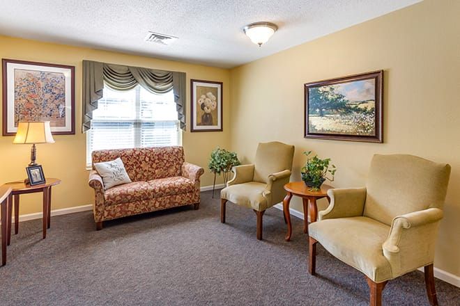 Cozy living room with a sofa, two chairs, and decorative elements.
