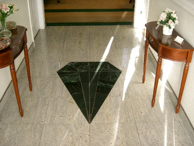 An optical illusion on a marble floor that appears as a three-dimensional geometric shape.