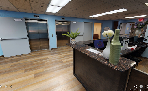 A modern office reception area featuring elevators and a stylish desk.