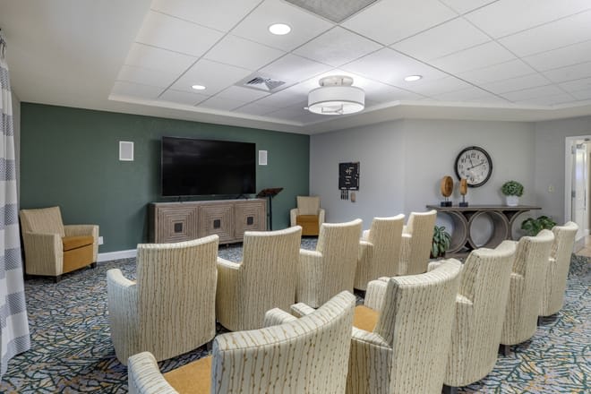 A modern conference room equipped with comfortable seating and a large television for presentations.