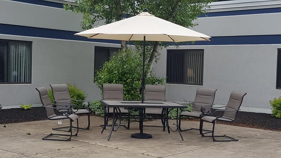 Outdoor patio set with a table, chairs, and a large umbrella.