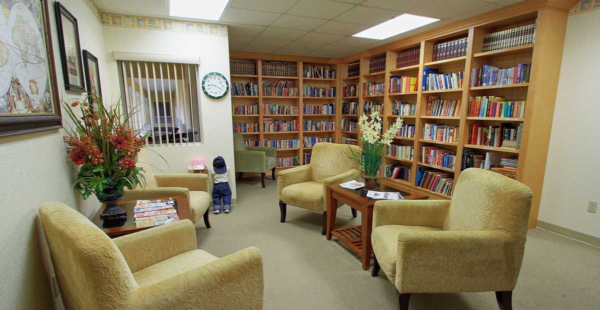 A cozy library reading area with bookshelves and comfortable seating.