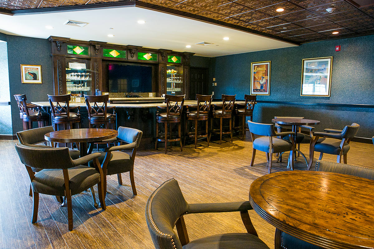 An inviting bar and restaurant interior with wooden tables and chairs.