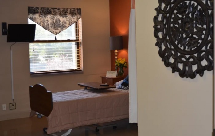 A cozy and well-lit hospital room with a neatly made bed and decorative elements.
