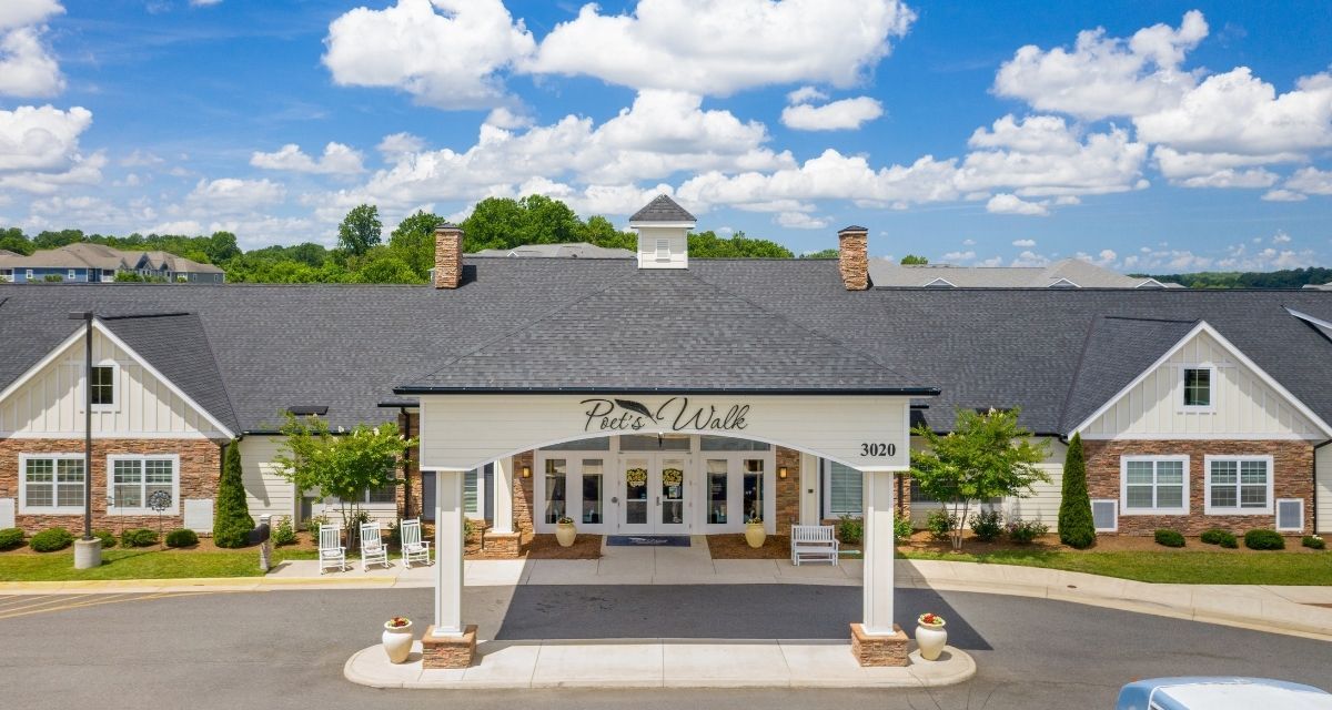 Front view of an elegant building entrance under a partly cloudy sky.