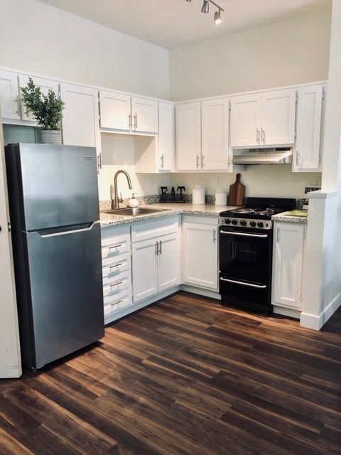 A modern kitchen with white cabinets and stainless steel appliances.