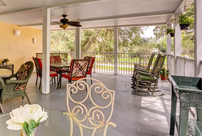 A spacious screened patio with dining furniture and rocking chairs.