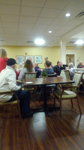 A lively gathering in a dining hall, where individuals are engaged in conversation and enjoying their time together.