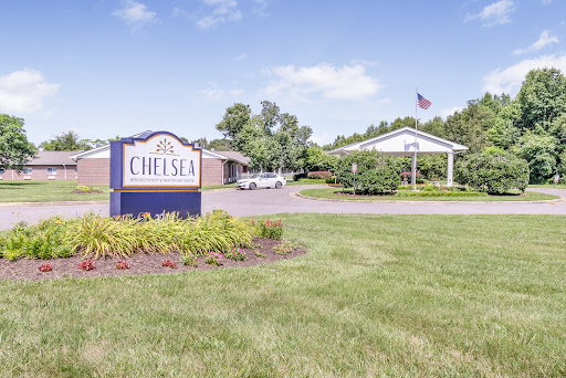 Entrance to Chelsea, showcasing well-maintained landscaping and a clear blue sky.
