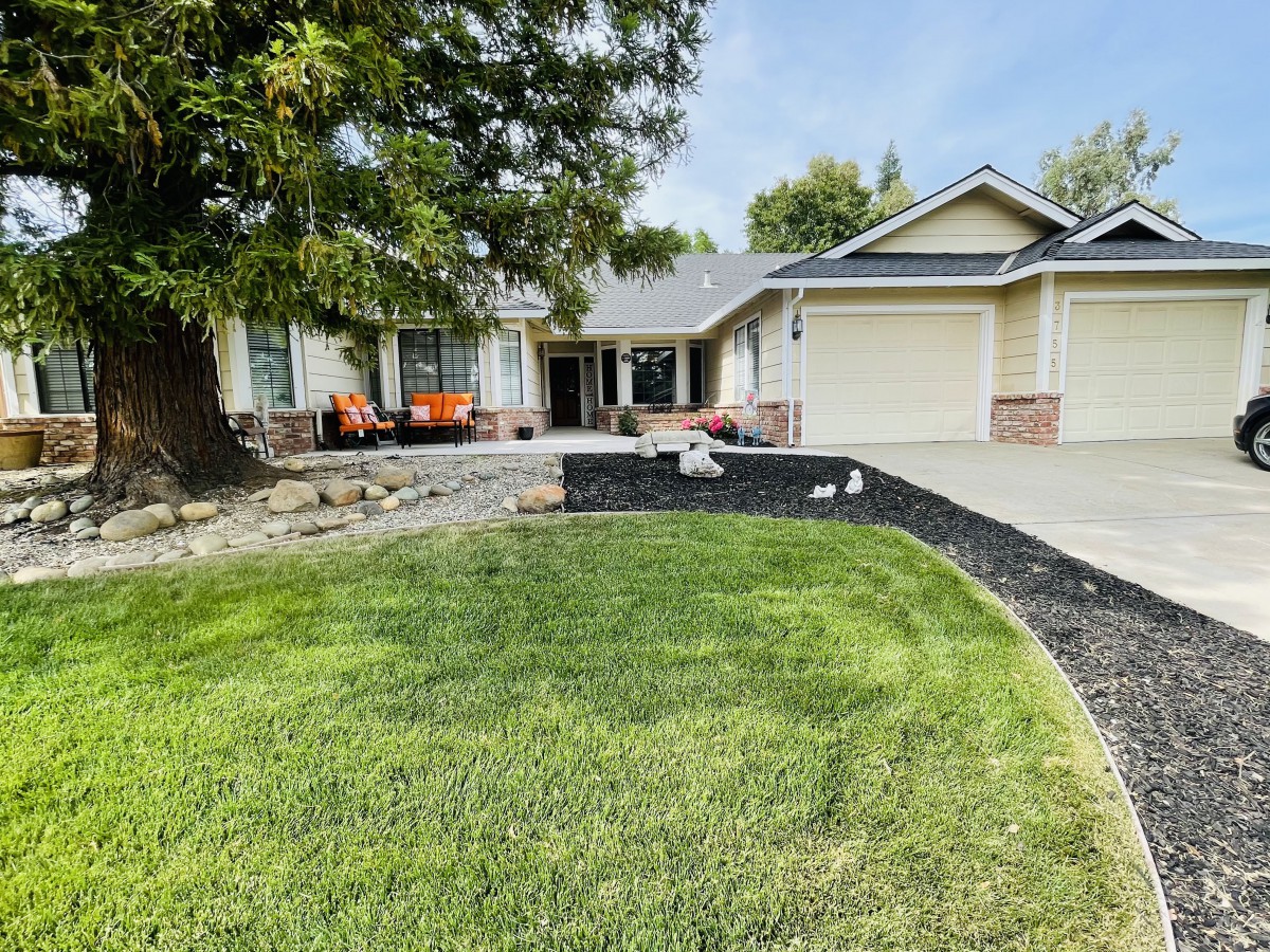 A suburban house with a well-maintained lawn and driveway.